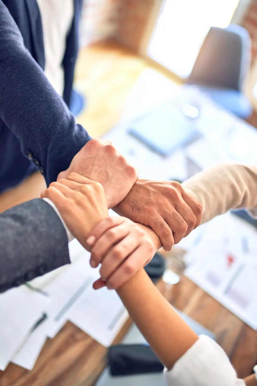 Mains unies autour d'une table de travail