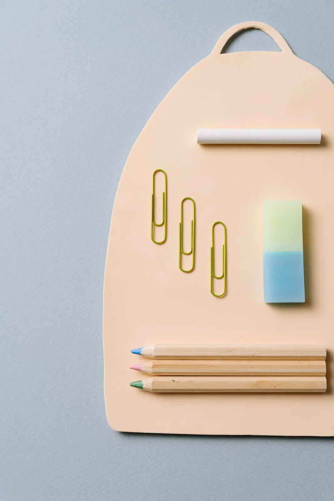 Eraser, pencils and paper clips on a paper folder